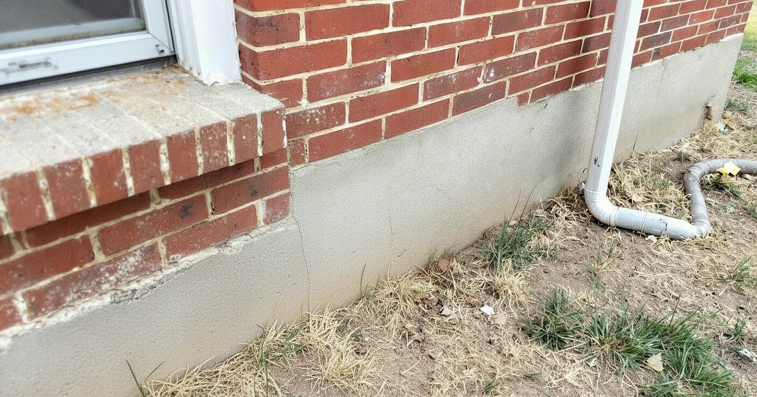 Illustrative example: the same Tulsa home after foundation repair, the stem wall corner patched, the displaced brick reset and the soil regraded